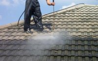 Photo of roof tiles being jet washed clean.
